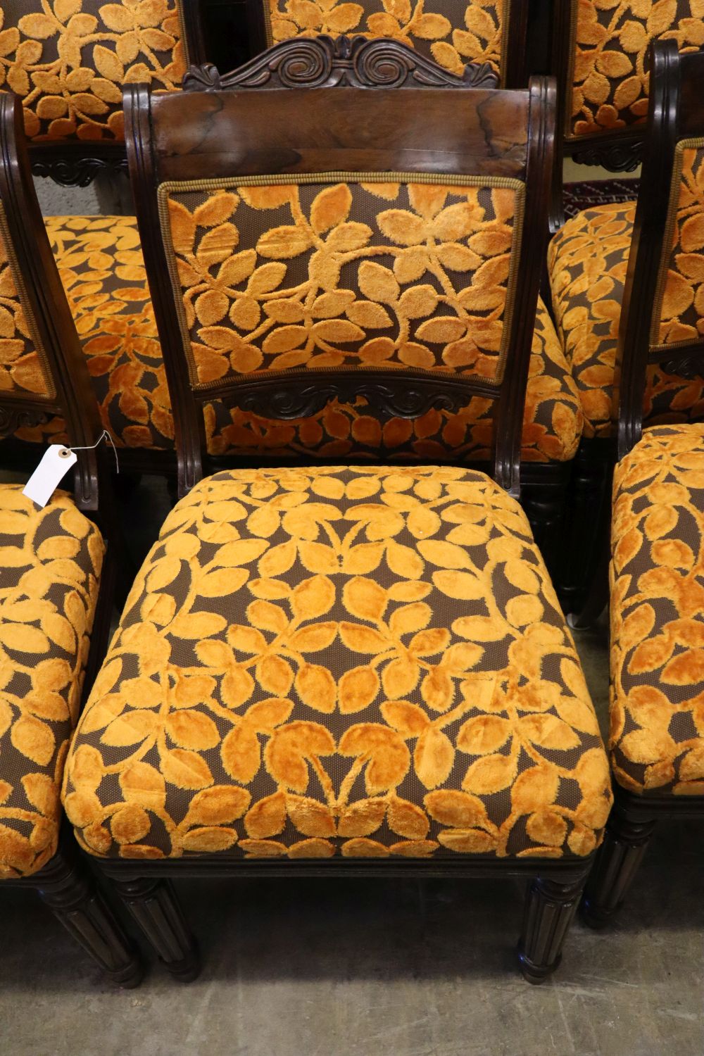 A set of six early 19th century Anglo-Indian rosewood dining chairs, with carved frames and padded seats on fluted legs